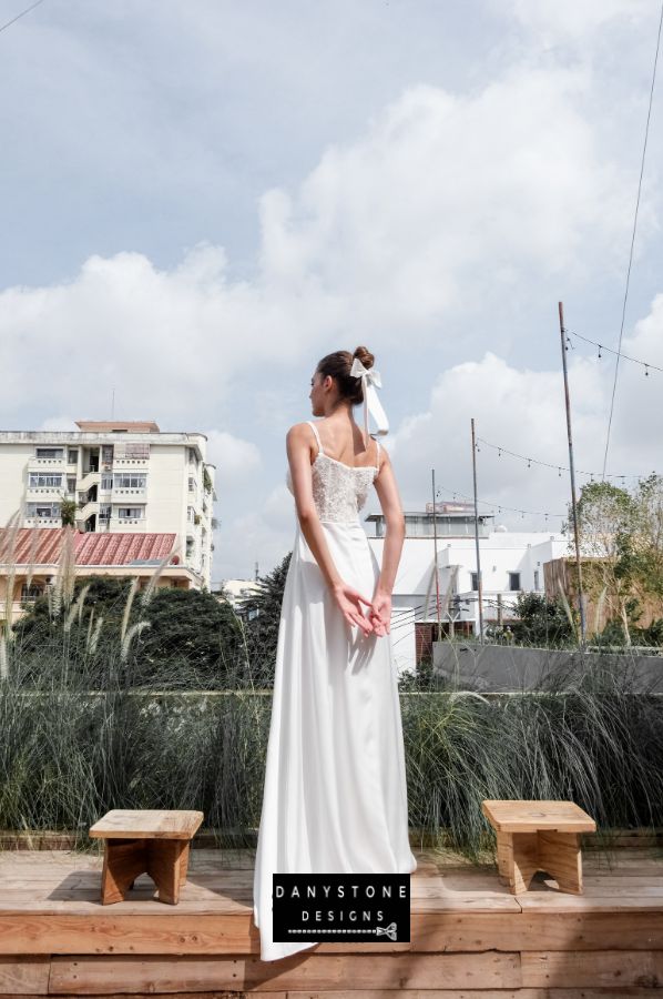 A detailed side view focusing on the satin and 3D floral lace elements of the dress.