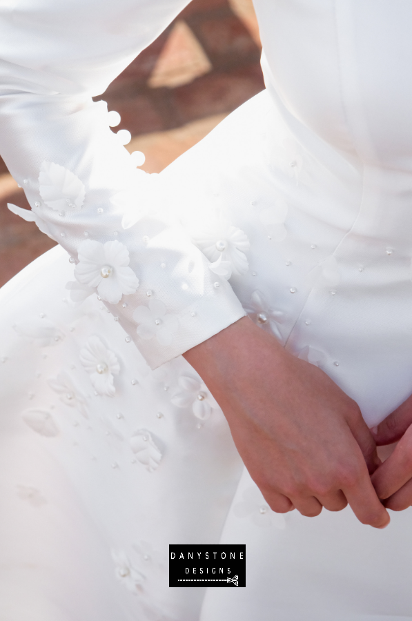 A close-up view of the embossed flower detailing on the 7-piece tafta dress with long sleeves.
