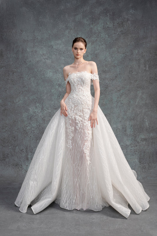 Woman wearing a white lace wedding dress against a gray background