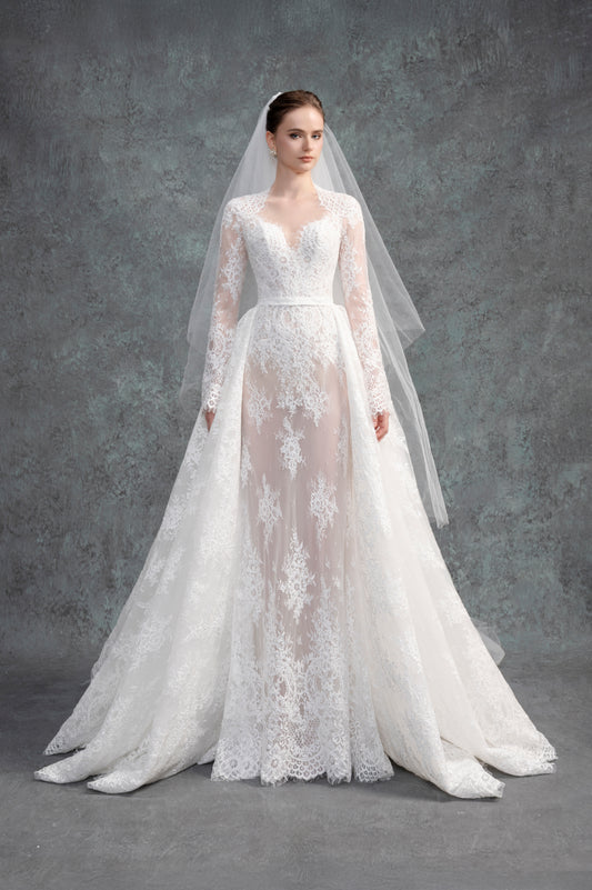 White lace wedding dress with long sleeves and a matching veil on a gray background