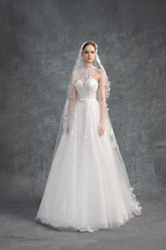 White wedding dress with a long train and veil on a gray background