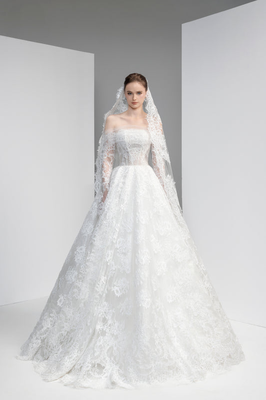 White wedding dress with lace details and a veil on a plain background