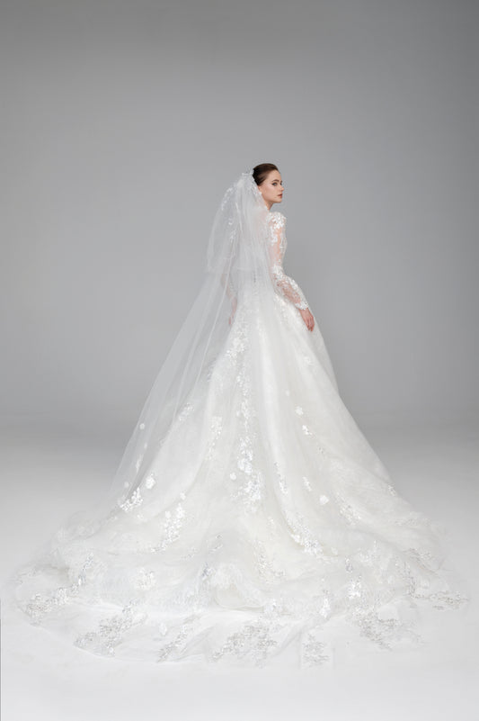 White wedding dress with long sleeves and a veil on a gray background