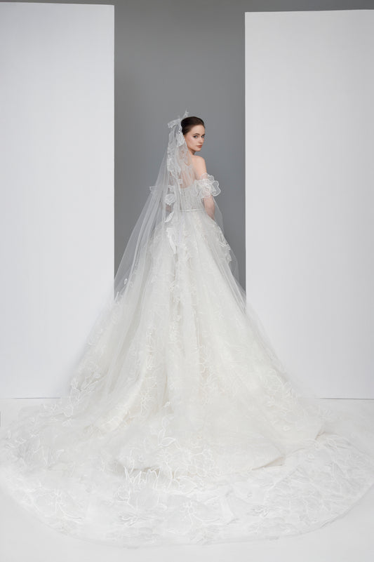 White wedding dress with a long veil on a white background