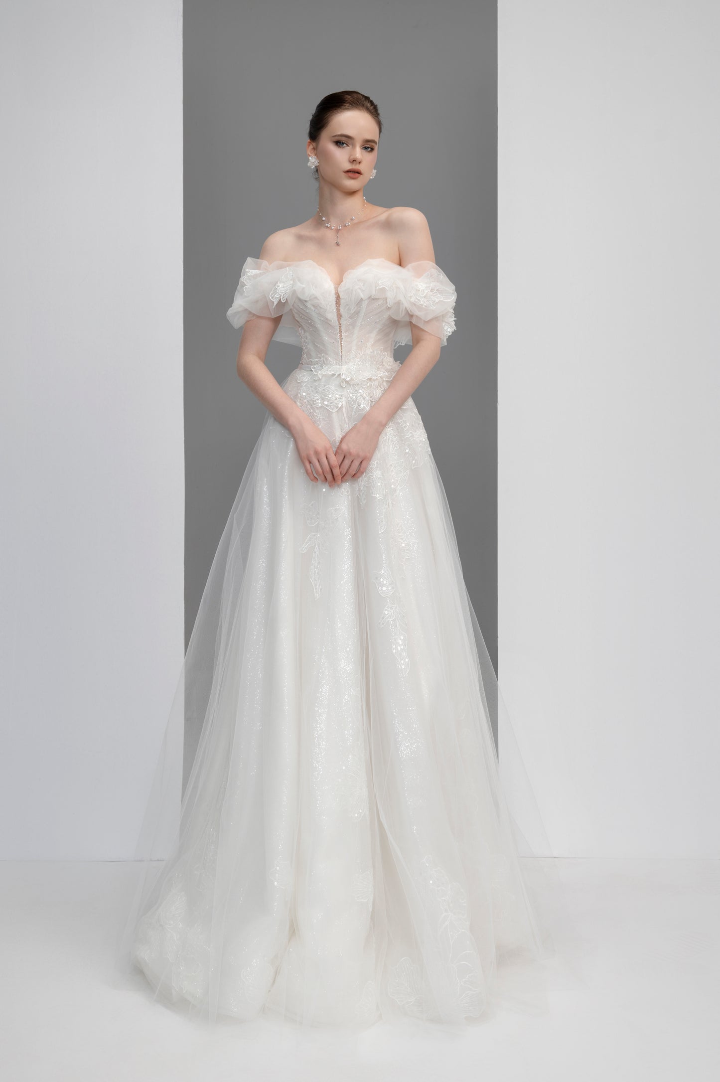 White wedding dress with floral details on a plain background