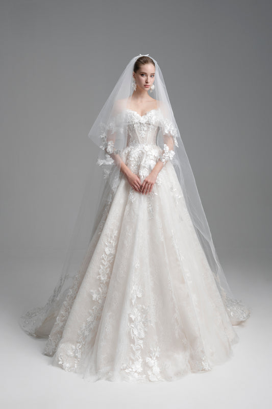 White wedding dress with floral details and a long veil on a gray background