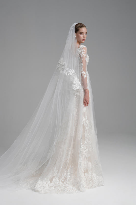 White wedding dress with floral details and a long veil on a gray background
