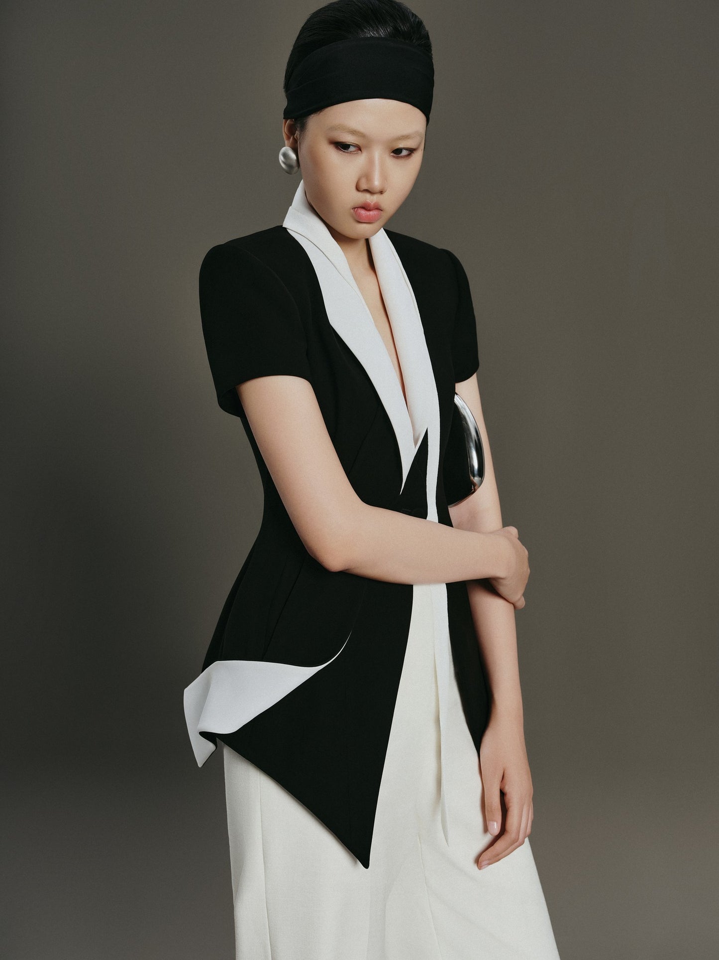 Woman wearing a black and white outfit against a gray background