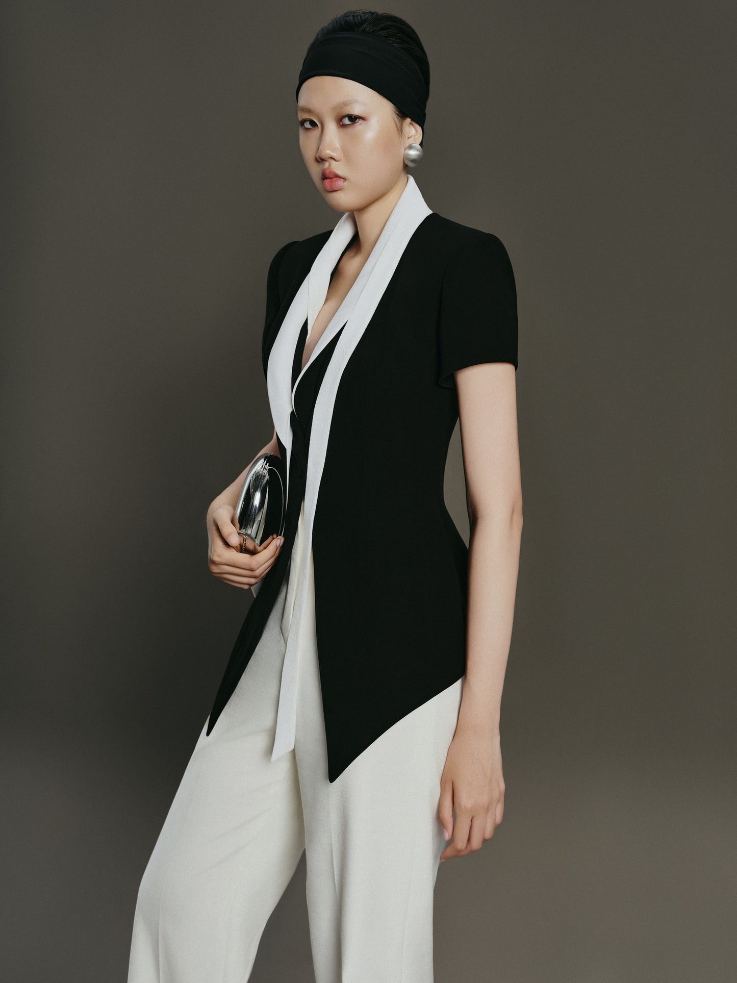 Woman wearing a black and white outfit against a gray background
