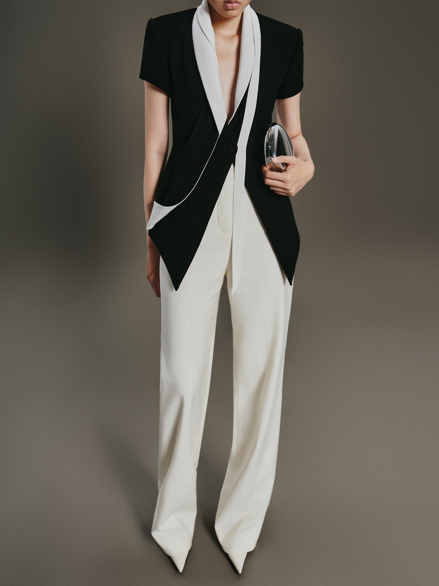 Person wearing a black and white outfit with a plain background