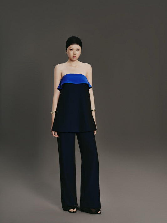 Woman wearing a blue and black outfit against a gray background