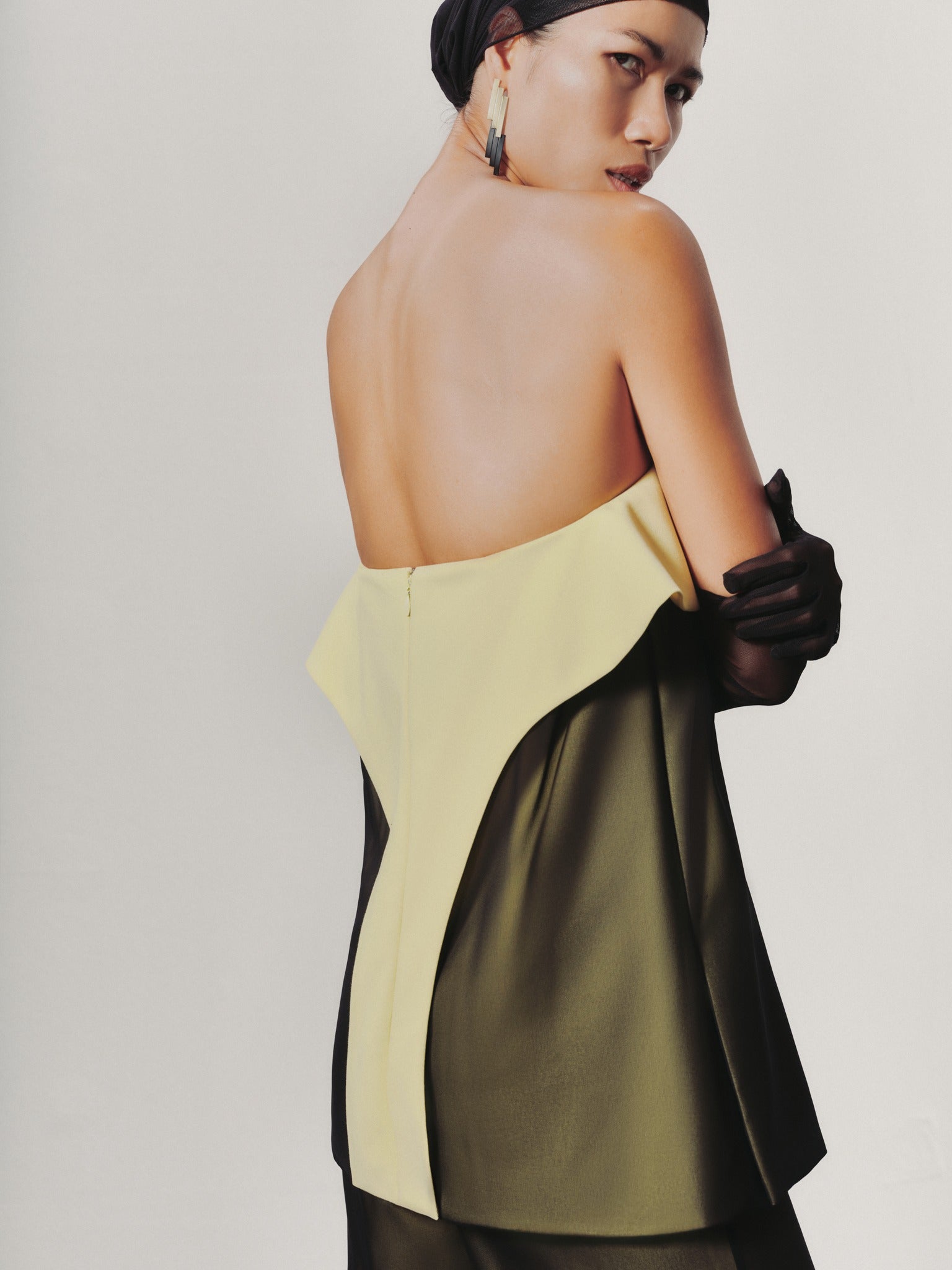 Woman wearing a two-tone dress with a plain background