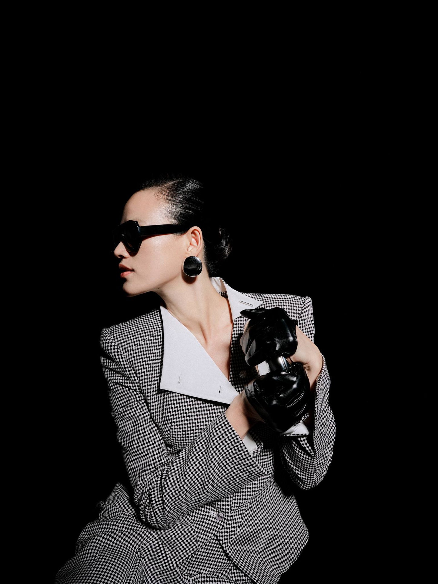 Person holding a camera against a black background