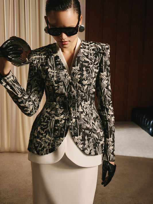 Woman wearing a patterned blazer and sunglasses indoors