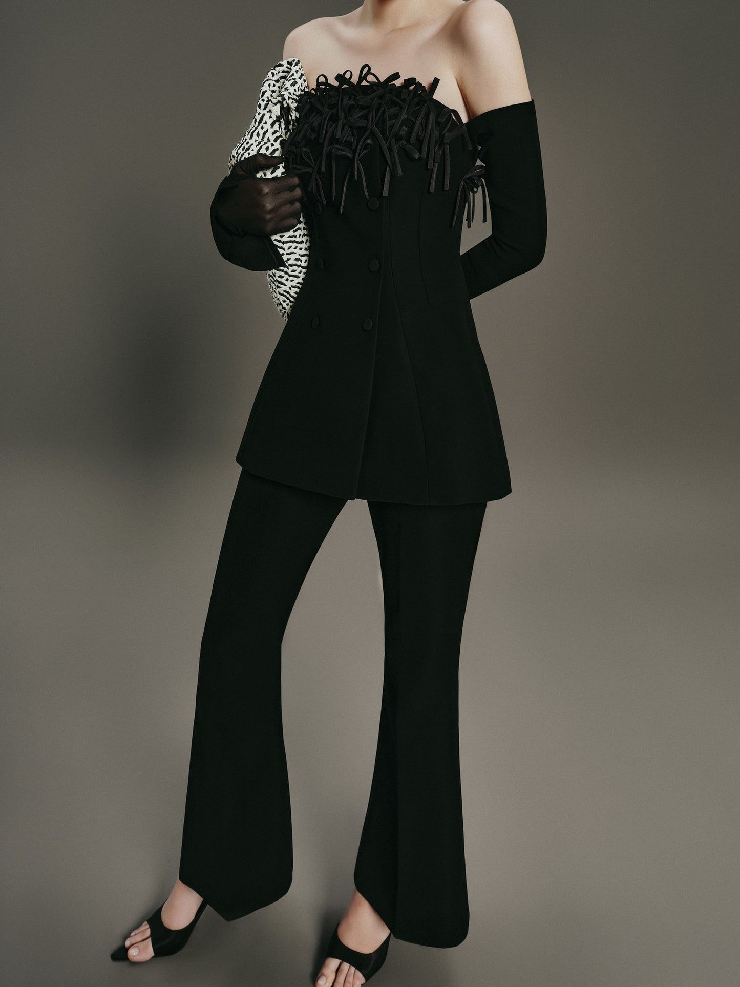 Black outfit with textured top and wide-leg pants on a gray background