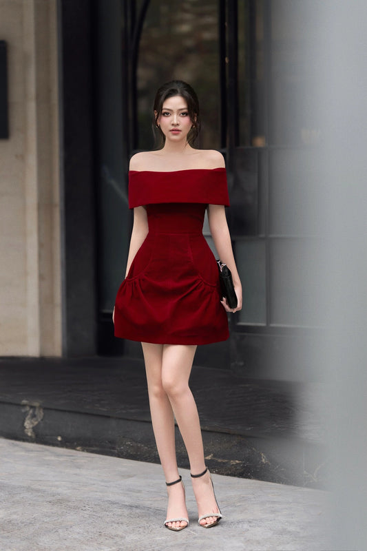 Woman in a red off-shoulder dress standing outdoors.