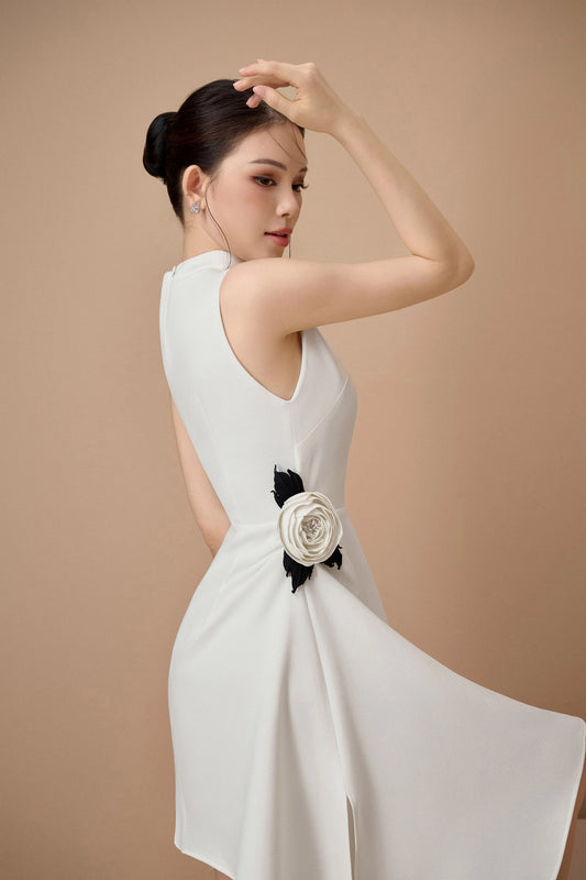 Woman wearing a white dress with a floral detail on a beige background