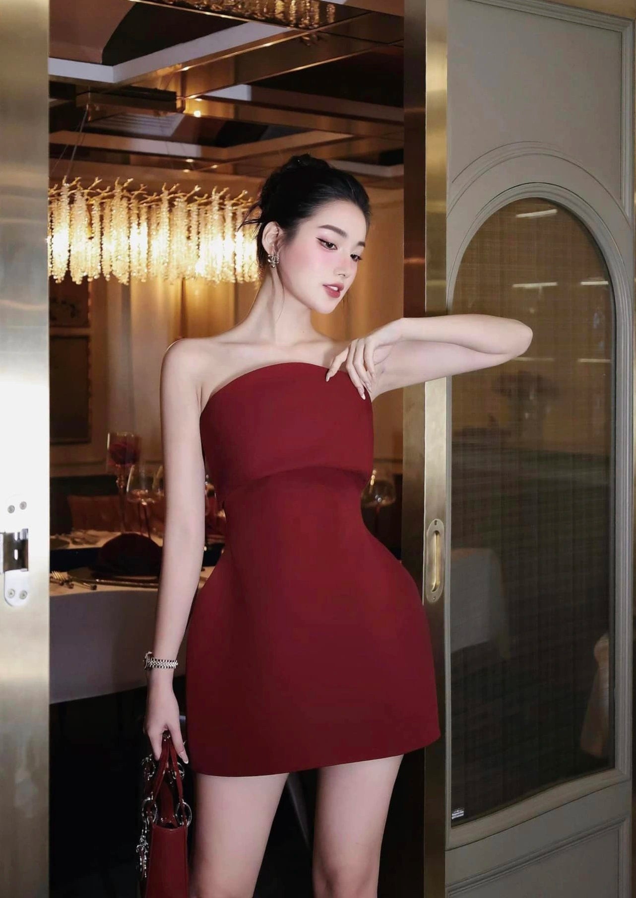 Woman in a red dress standing in an elegant interior setting