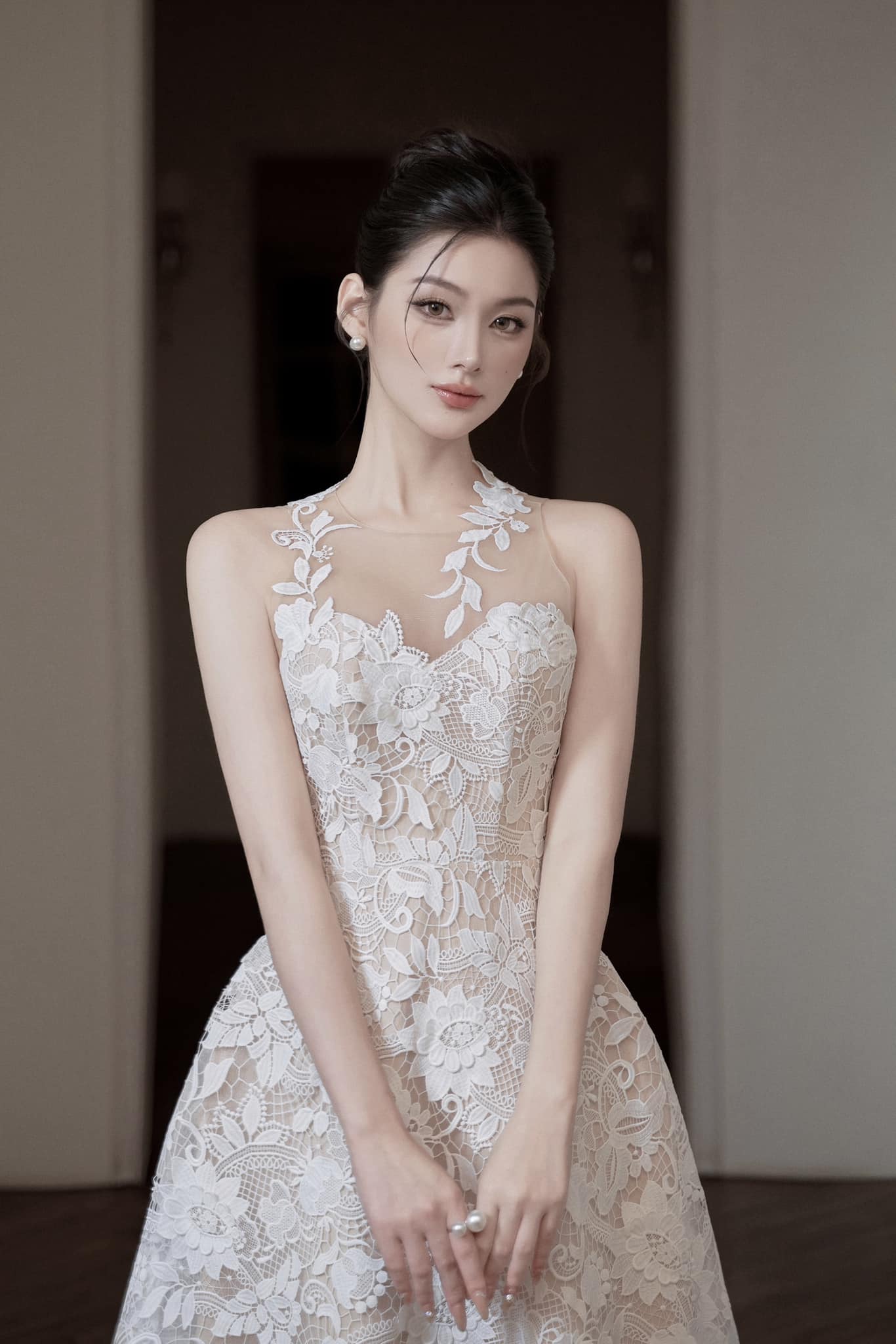 Woman wearing a white lace dress in an indoor setting