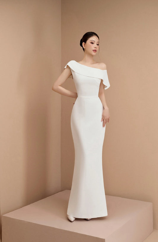 Woman wearing a white off-shoulder gown against a beige background