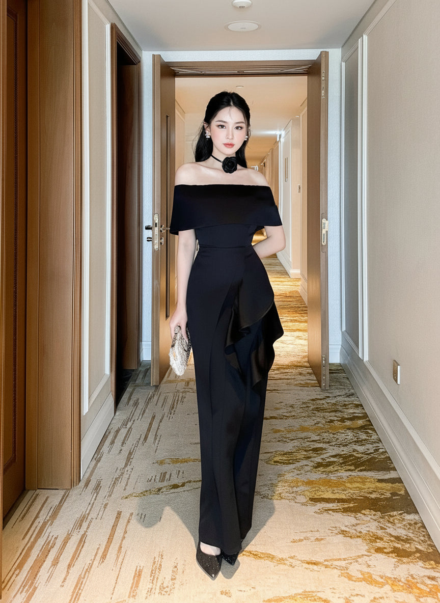 Woman in a black off-shoulder dress standing in a hallway.