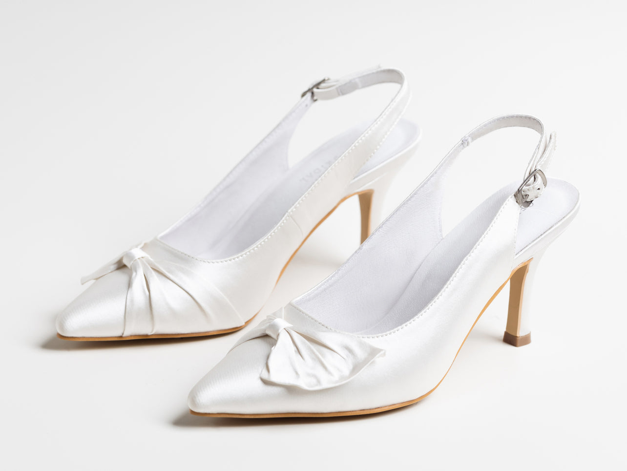 Pair of white satin high-heeled shoes on a light gray background