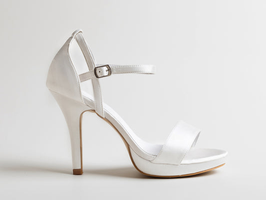 White high-heeled sandal on a light gray background