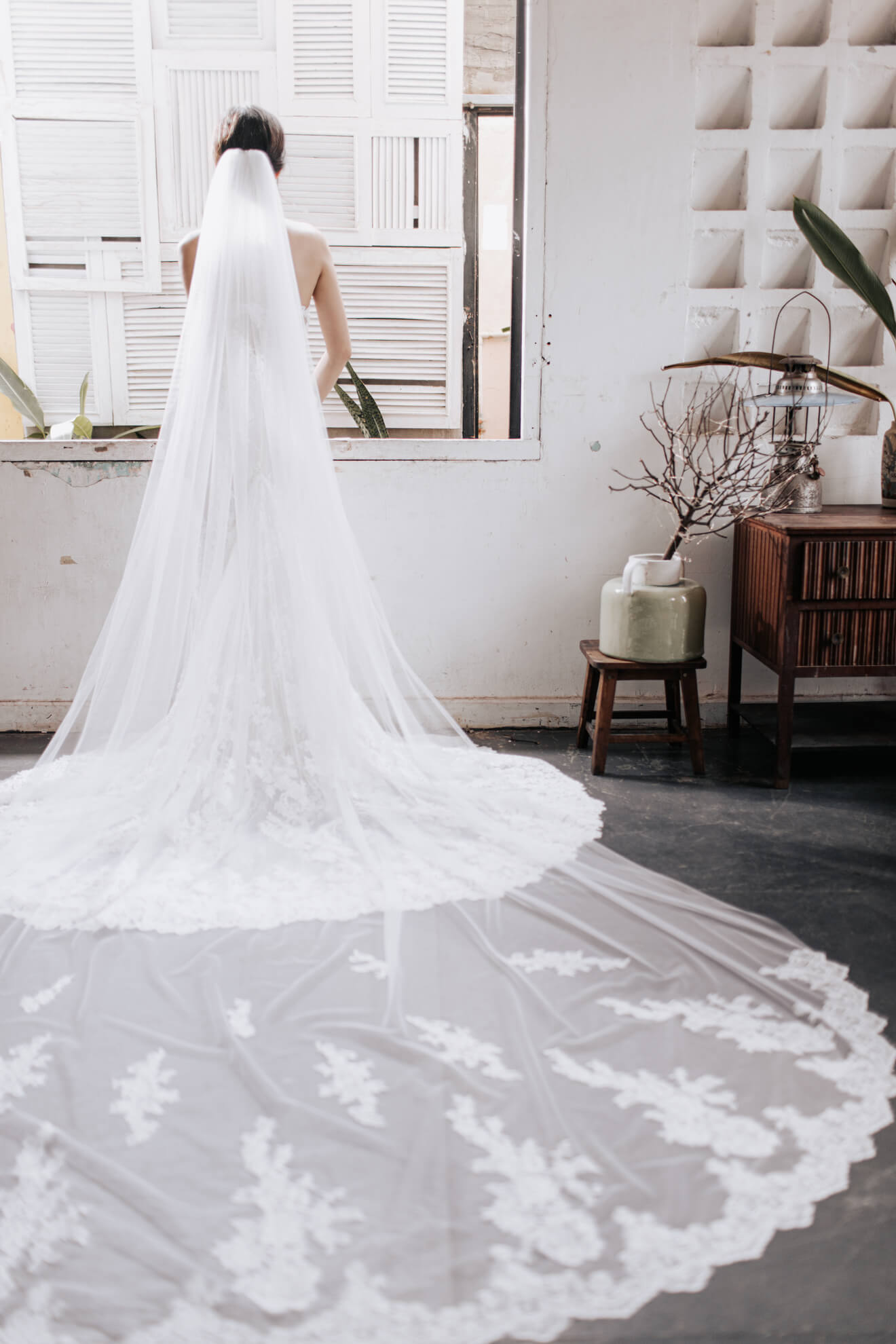 Person wearing a long, elegant wedding veil indoors.