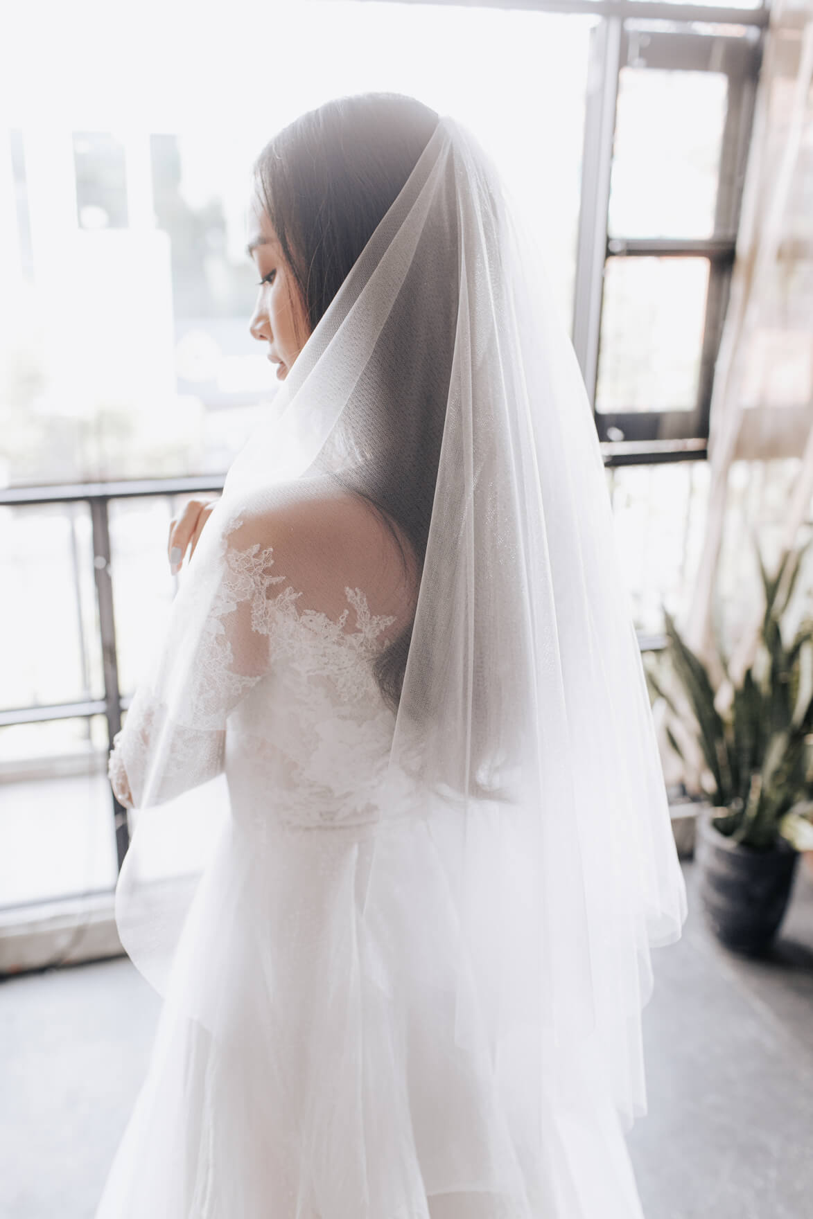 Bride wearing a white wedding dress with a veil indoors.