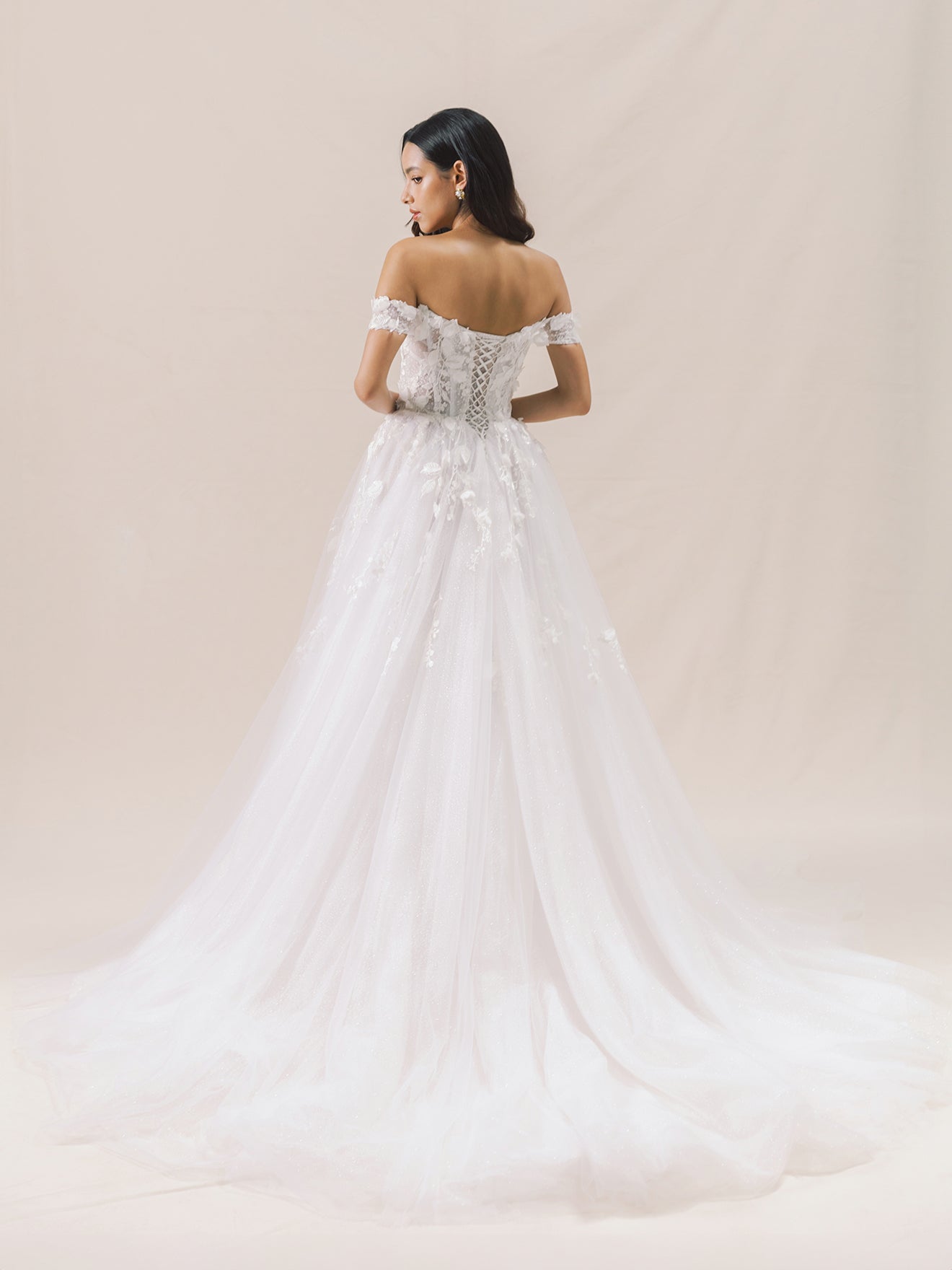 Woman wearing a white wedding dress with a soft beige background