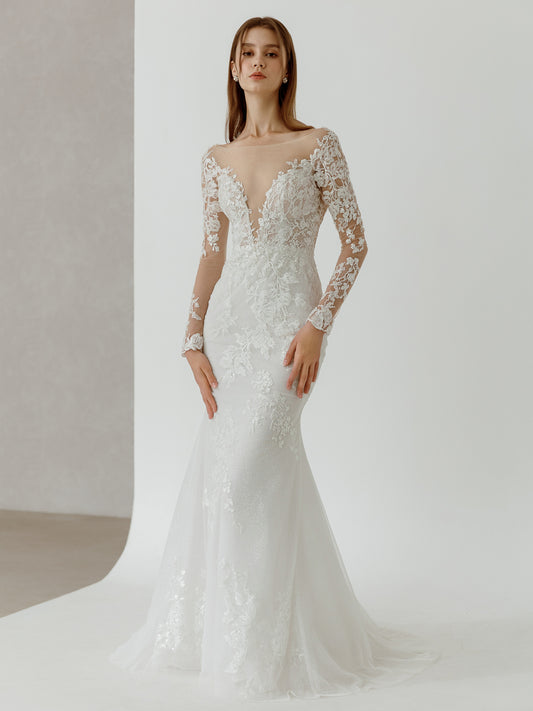 White lace wedding dress with long sleeves on a plain background