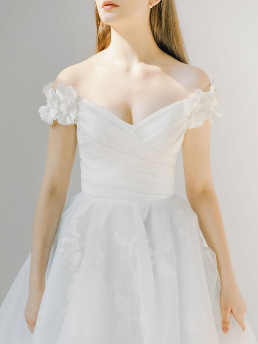 White wedding dress with floral details on a plain background