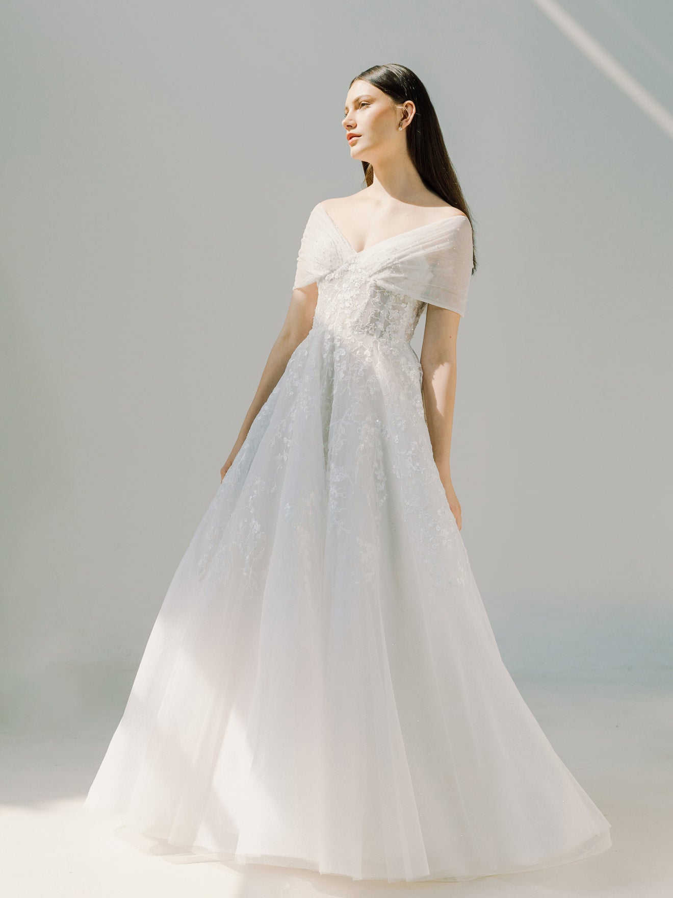 Woman wearing a white wedding dress against a light gray background