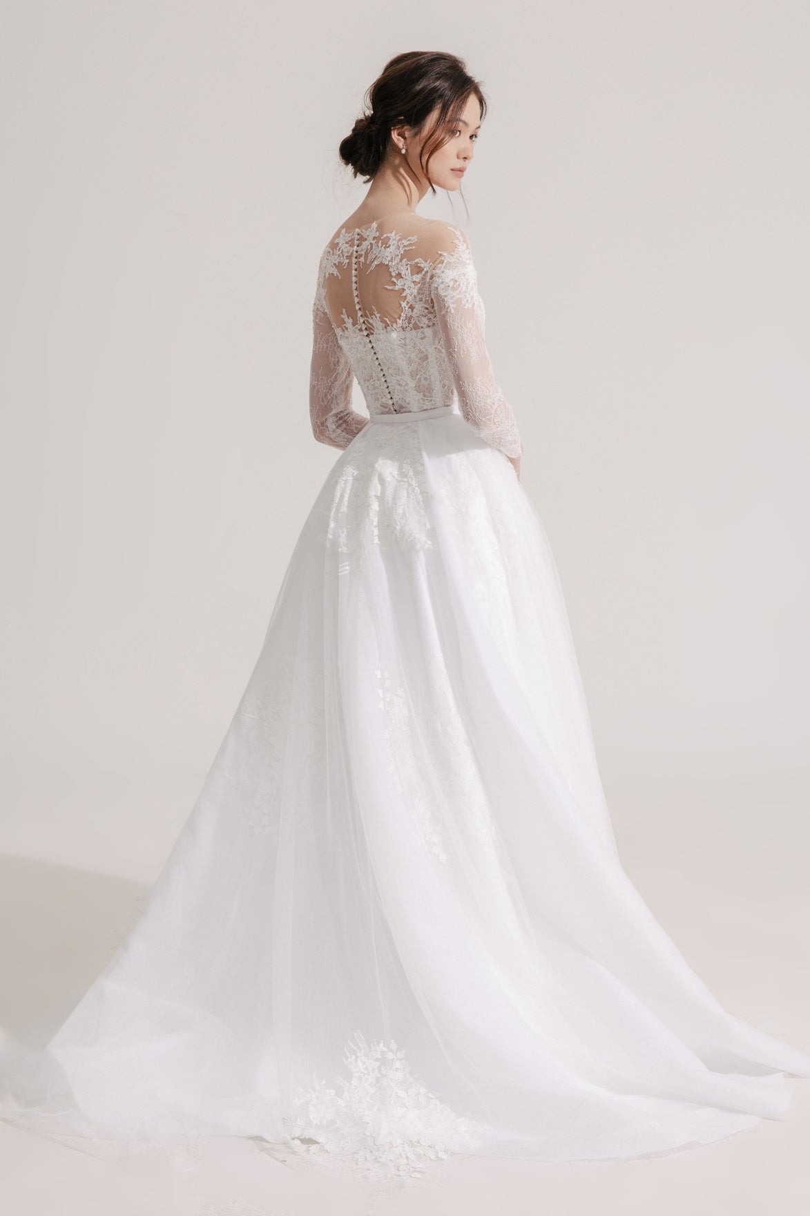 White wedding dress with lace detailing on a plain background