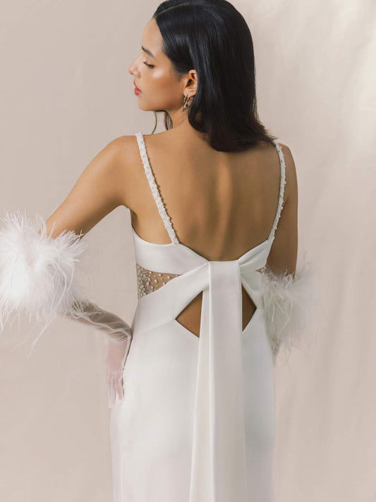 Woman wearing a white wedding dress with a open back design.