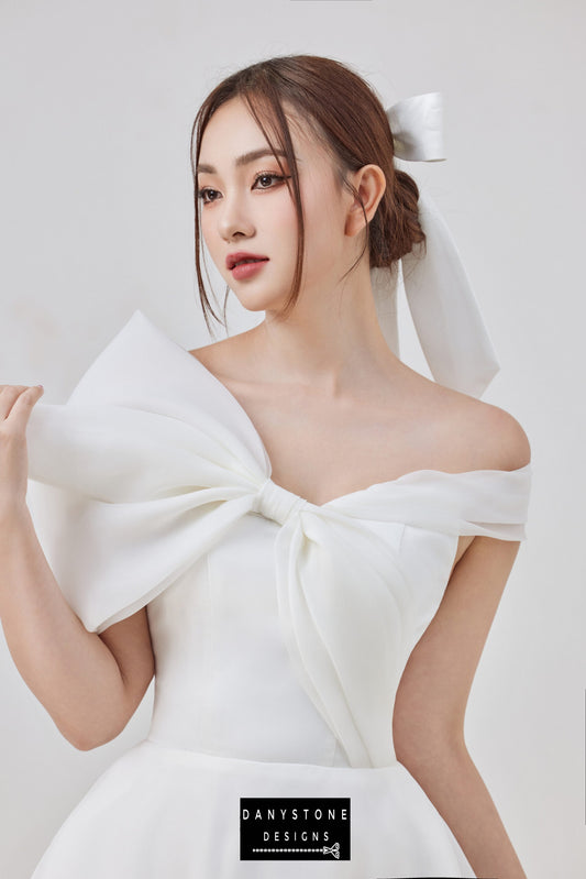 Bride in off-shoulder wedding dress with large bow detail