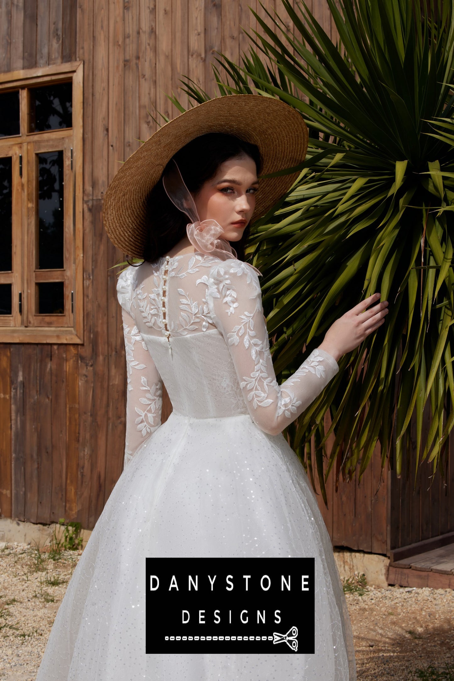 Back view of the bride in a Cinderella puffy wedding dress with leaf motifs and 3D flowers, standing in a garden