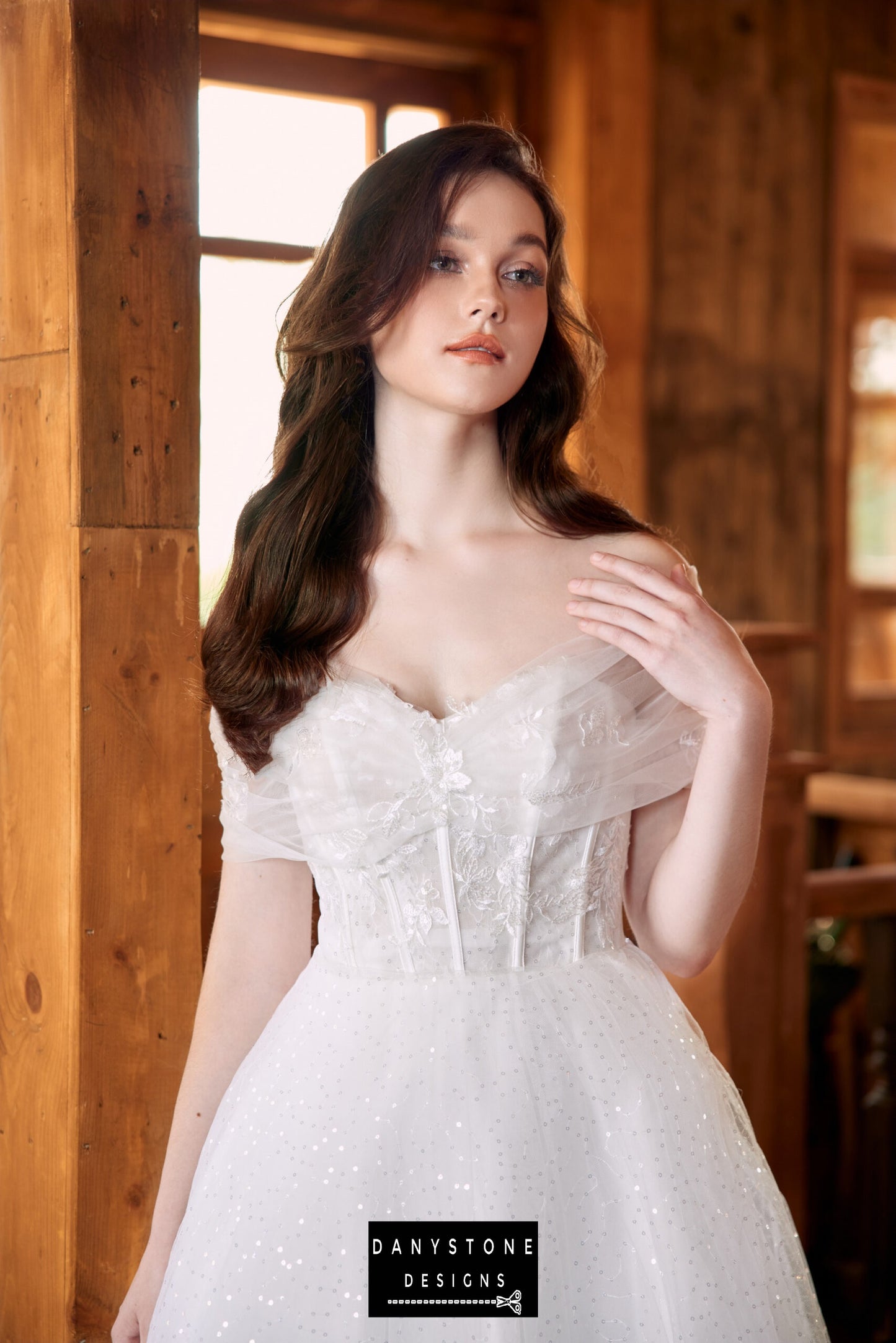 Close-up of the bride in a strapless wedding dress with intricate lace detailing, looking into the distance.