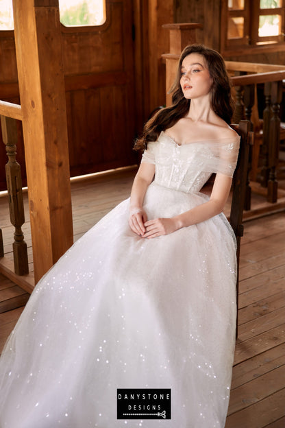 Bride sitting gracefully in a strapless wedding dress with a voluminous tulle skirt and lace bodice.