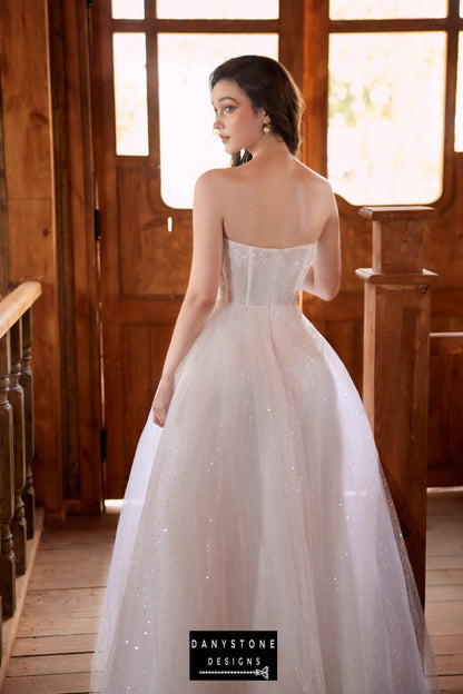 Back view of the bride in a strapless wedding dress with a flowing tulle skirt and lace bodice.