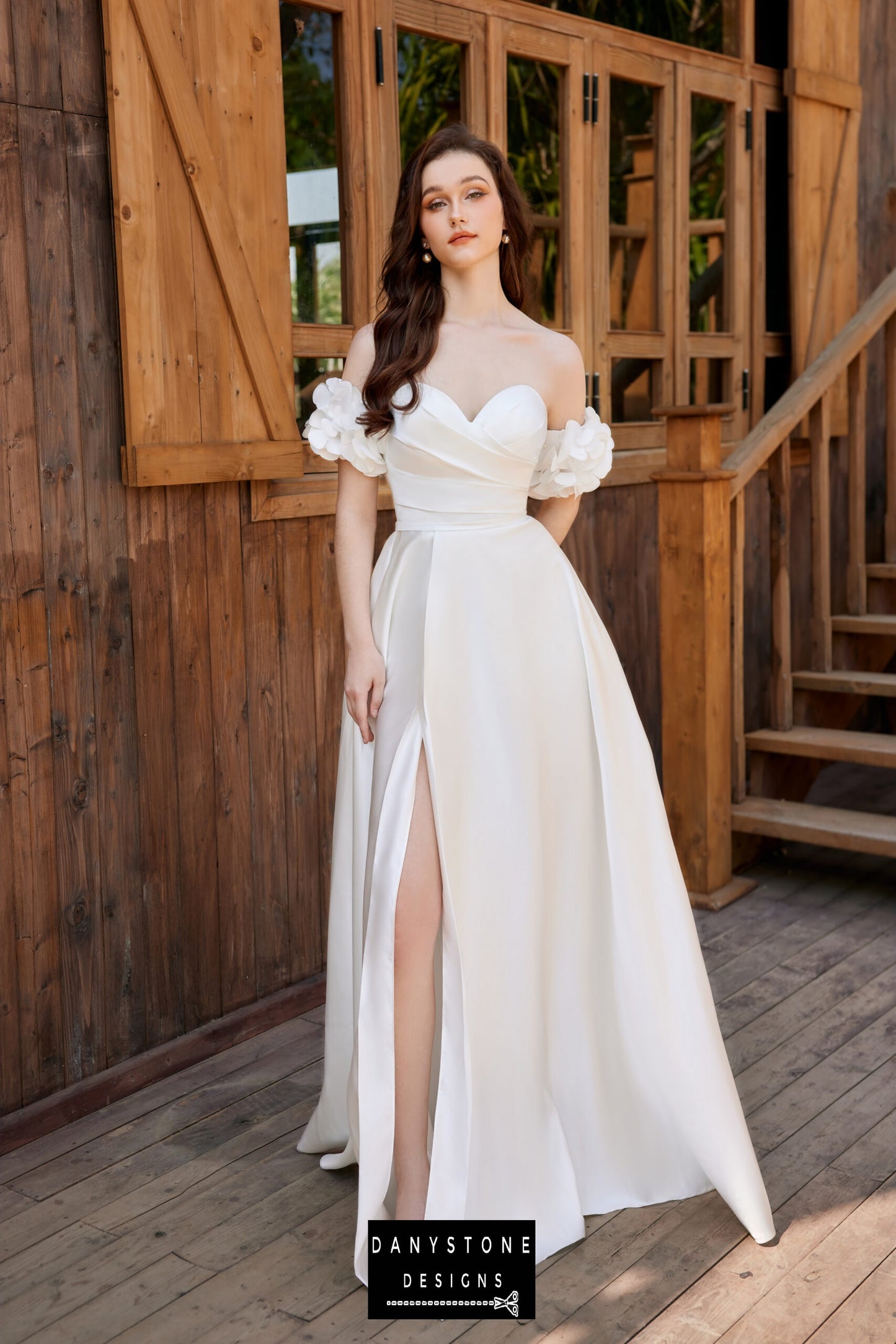 Close-up of the bride in a pleated strapless wedding dress with loose floral sleeves and a high slit.