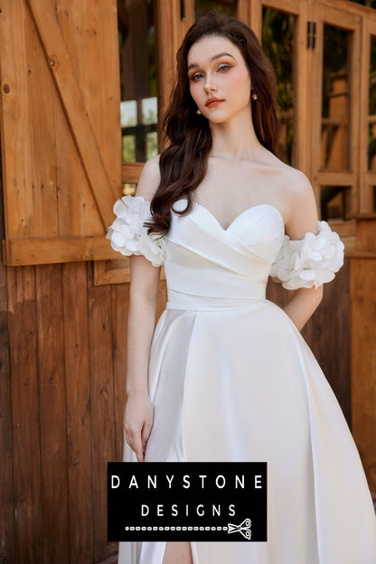 Bride in a pleated strapless wedding dress with loose floral sleeves, standing in front of a rustic wooden door