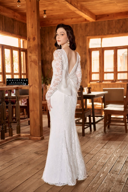 Sophisticated lace wedding dress with long sleeves and bow detail, highlighting fishtail silhouette - Danystone Designs.