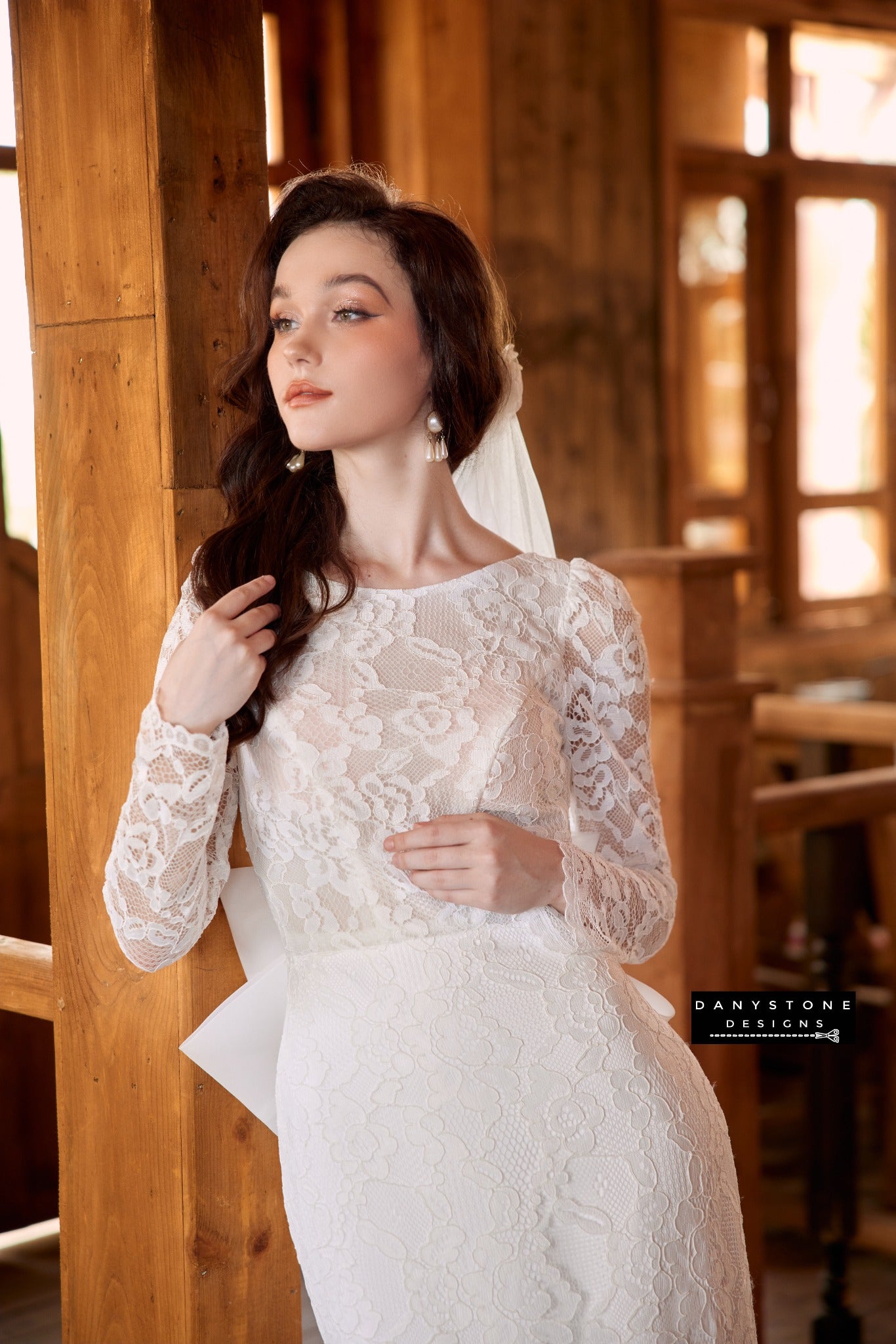 Classic boat neck lace wedding dress with bow at the back, perfect for a romantic bridal look - Danystone Designs.