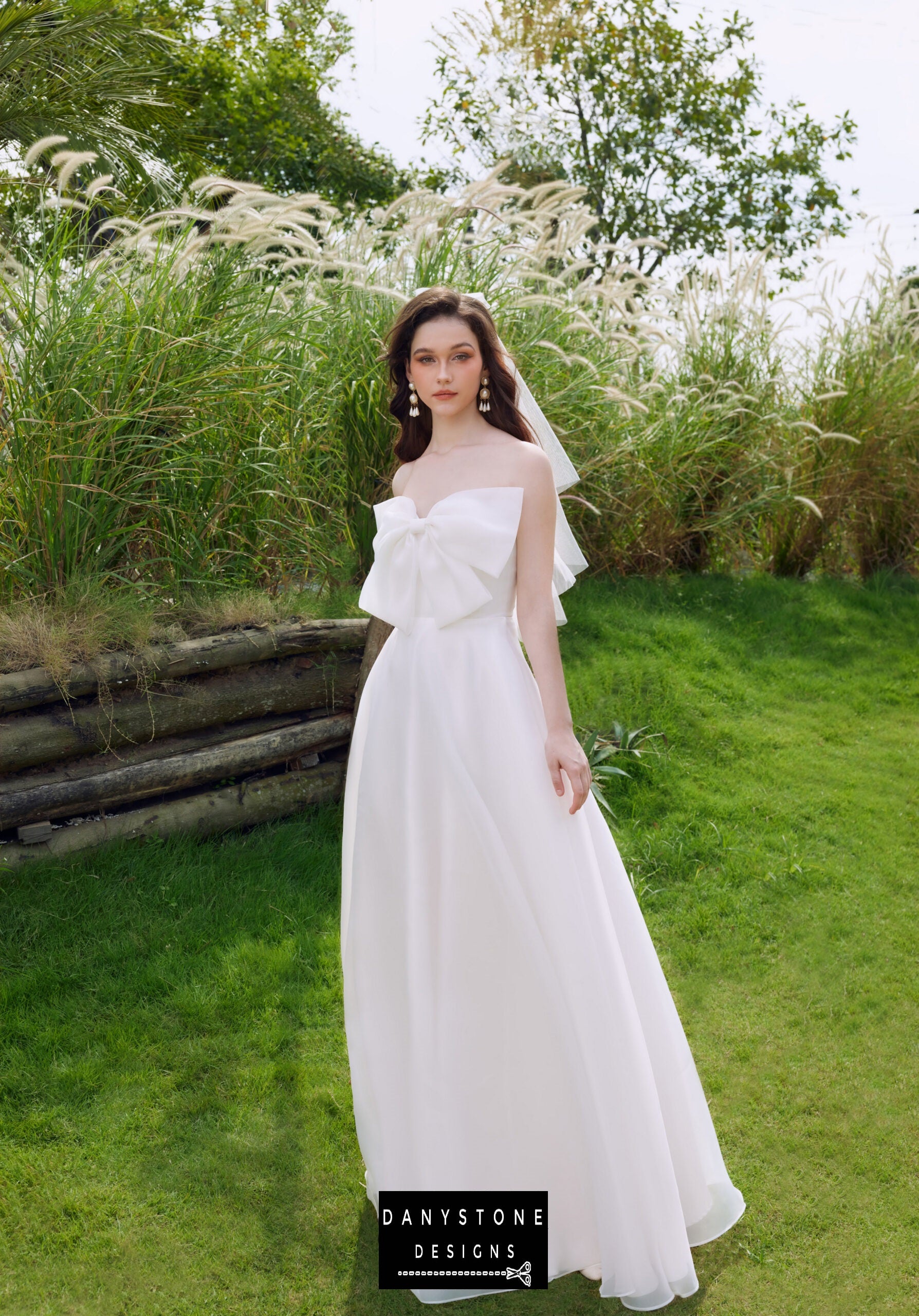 Modern wedding dress with a large bow at the chest, perfect for the stylish bride - Danystone Designs.