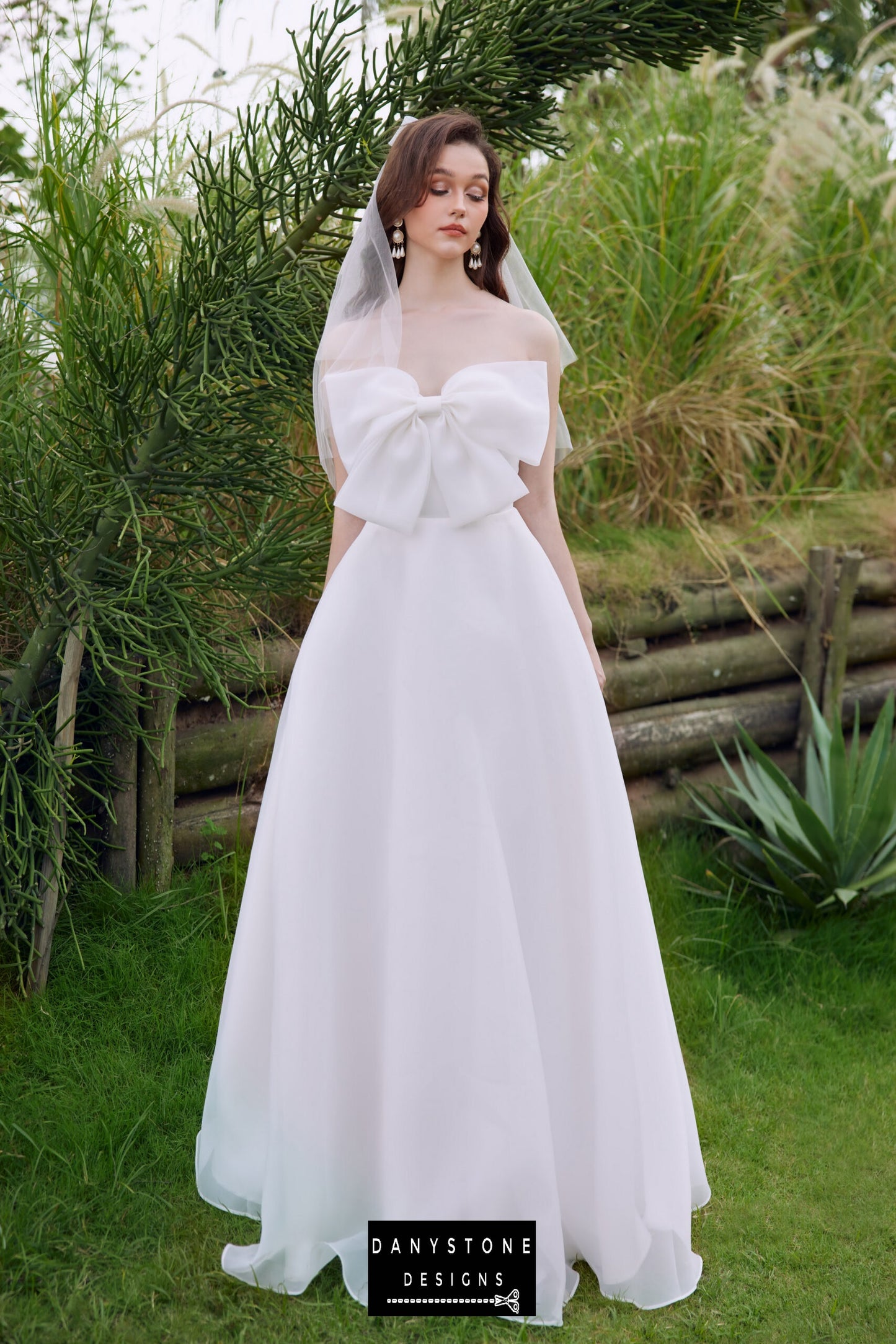 Full-length view of the elegant strapless wedding dress with bow detail - Danystone Designs.