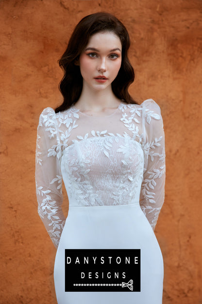 Close-up of the bride in a long-sleeved fishtail wedding dress with leaf motifs and 3D flowers, showing intricate lace details.