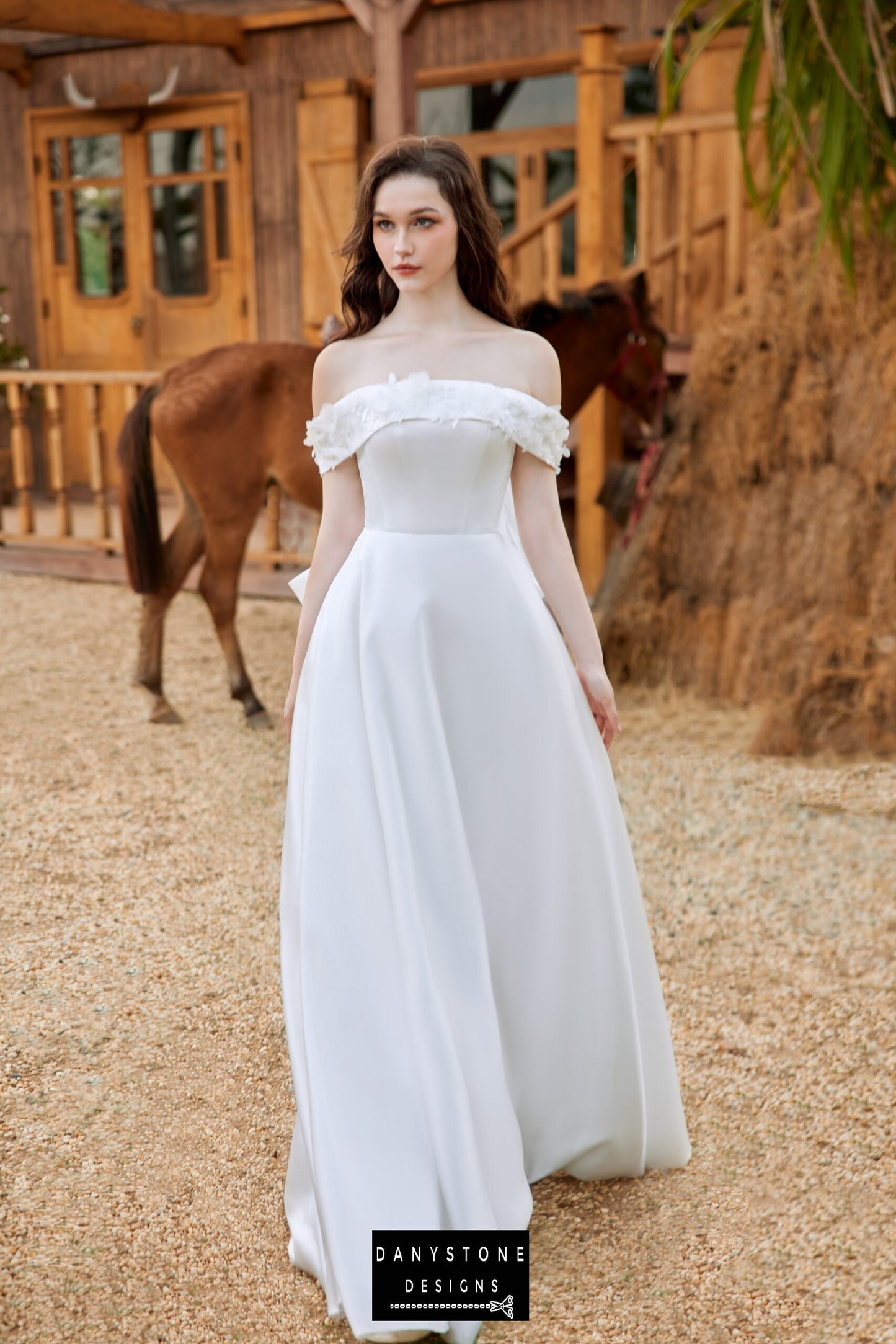 Off-the-shoulder wedding dress with round pine flower details, highlighting classic silhouette - Danystone Designs.