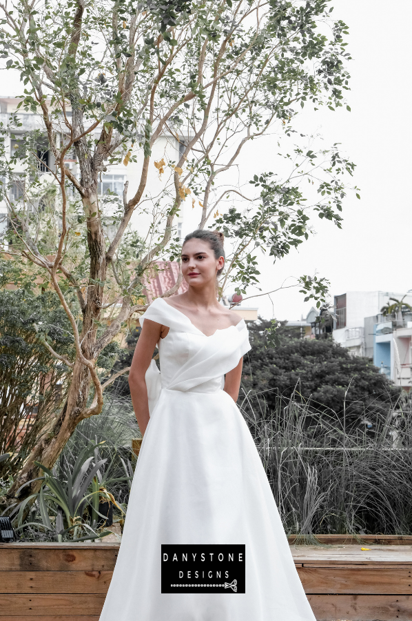 Enchanted Silk Chiffon Bridal Gown - Front View - Model posing with a bouquet, emphasizing the elegant A-line silhouette and the refined pleated bodice.