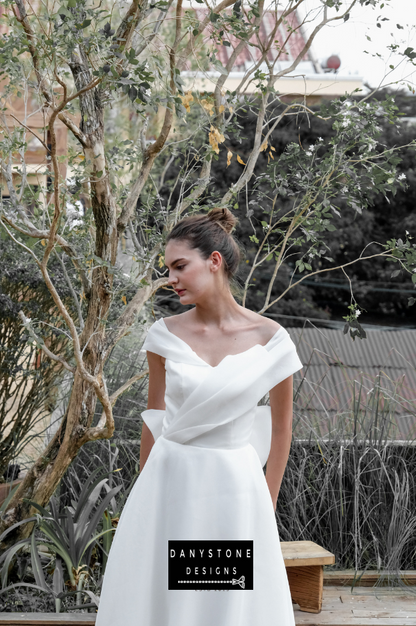 Elegant Bridal Gown with Pleated Silk Chiffon Bodice - Model posing in a lush garden, emphasizing the luxurious fabric and refined design of the gown.